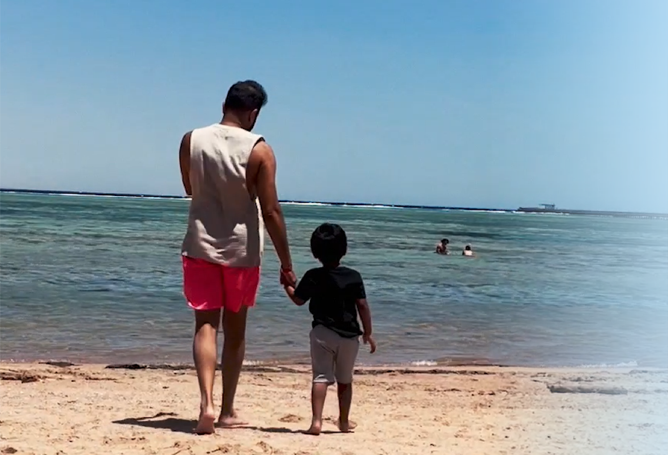 Founder walking on the beach with his son