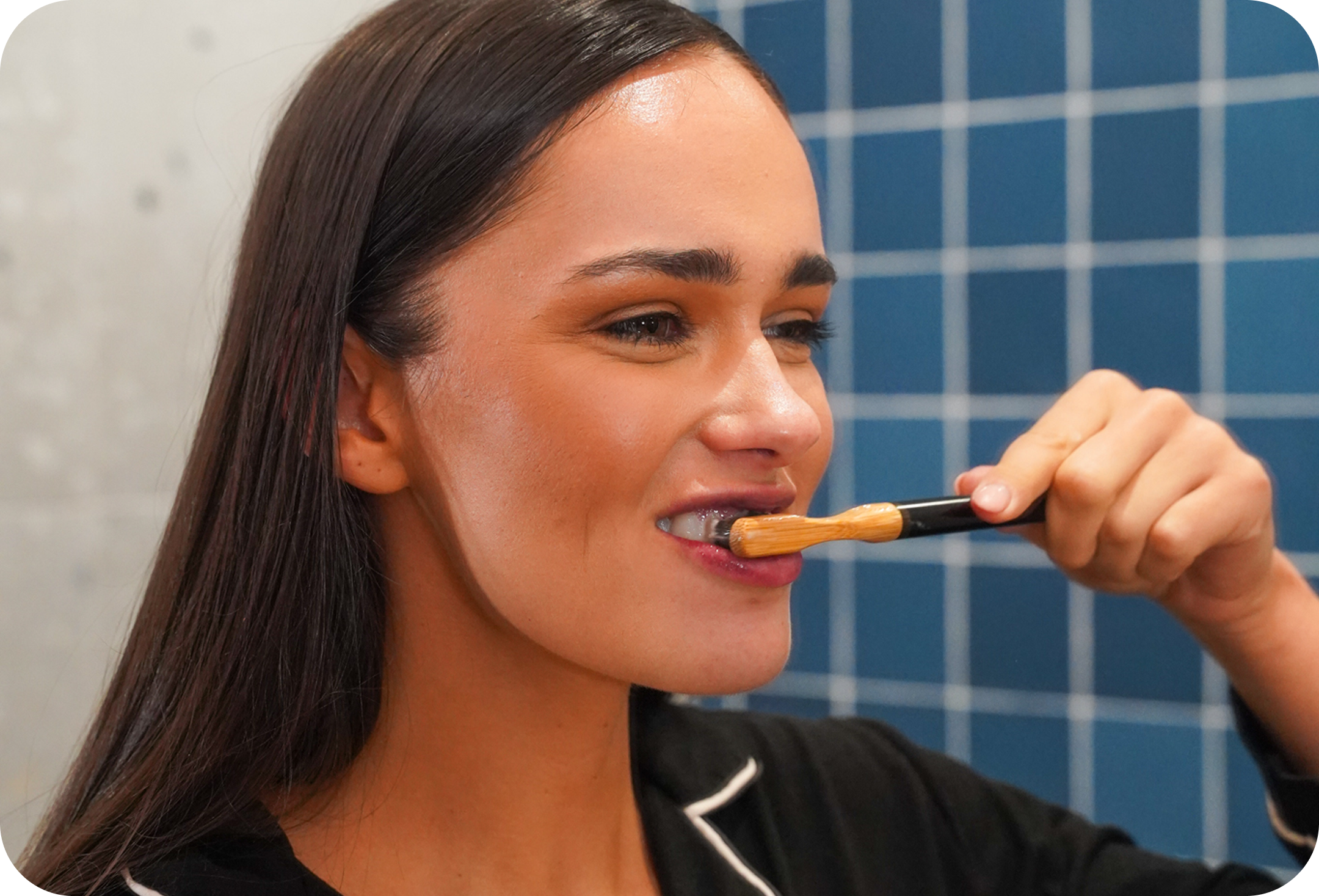 Person using sustainable bamboo toothbrush